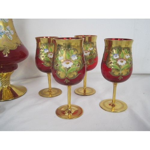 69 - A set of Murano or Venetian hand painted over gold four wine glasses and a handled jug .