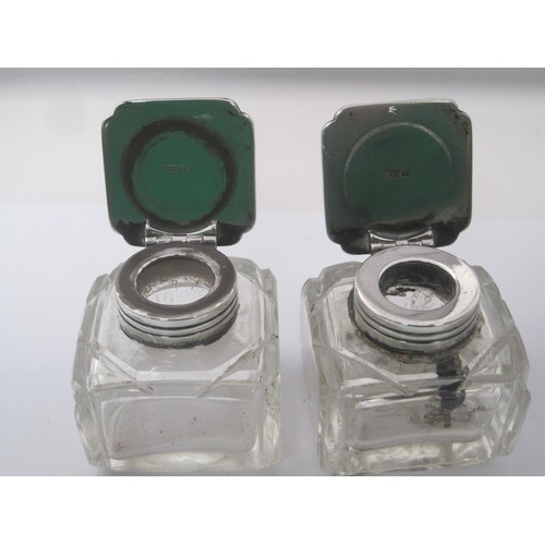 335 - A pair of silver mounted glass inkwells. The silver mounts bear the standard mark and date letter W