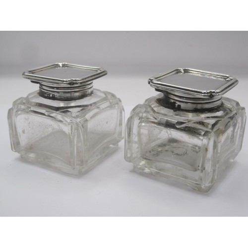 335 - A pair of silver mounted glass inkwells. The silver mounts bear the standard mark and date letter W