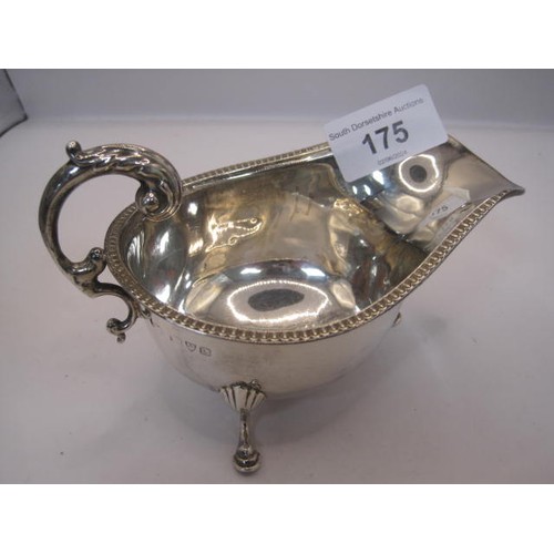 133 - Georgian style silver gravy boat with beaded rim, double scroll handle, on three hoof feet, partiall... 