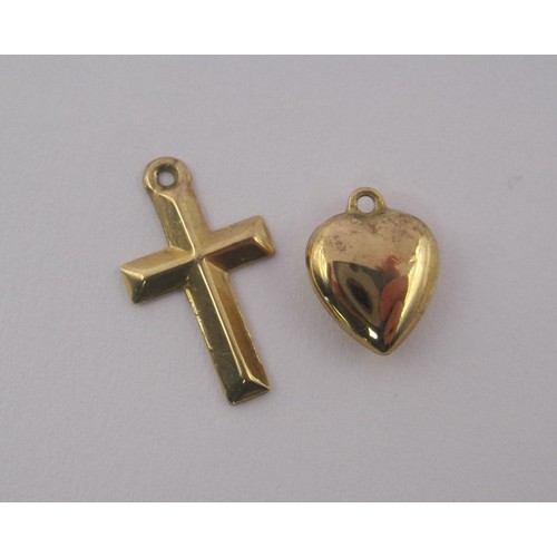 88 - A 9 carat gold cross charm with British hallmarks, and a yellow metal heart charm. Combined weight o... 