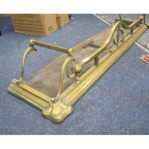 59 - An Art Nouveau style brass fender with scrolled ends and iron base. Width 124cm, depth 33cm