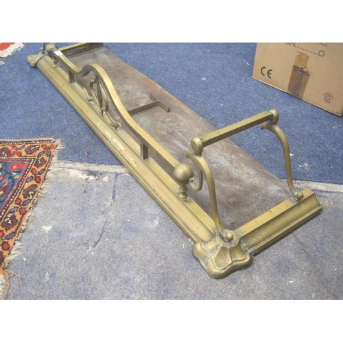 59 - An Art Nouveau style brass fender with scrolled ends and iron base. Width 124cm, depth 33cm