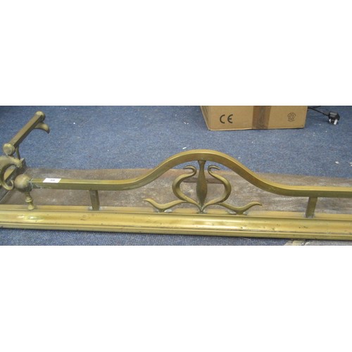 59 - An Art Nouveau style brass fender with scrolled ends and iron base. Width 124cm, depth 33cm