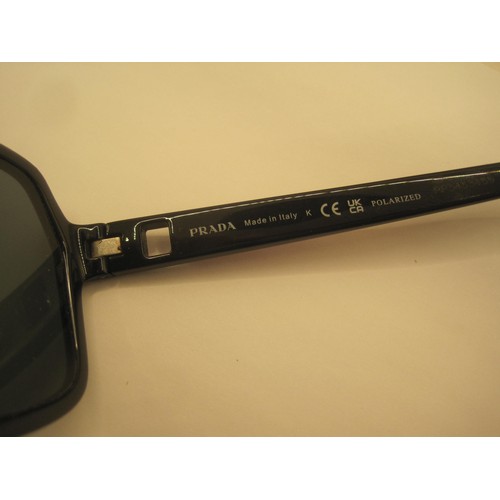 124 - A pair of polarized sunglasses marked Prada, matched with a soft carry case