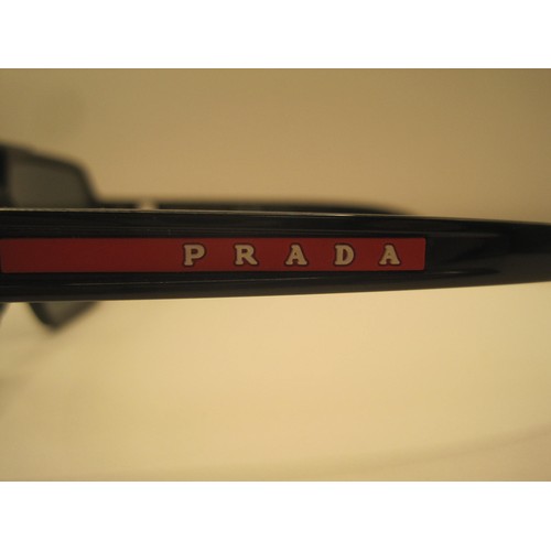 124 - A pair of polarized sunglasses marked Prada, matched with a soft carry case