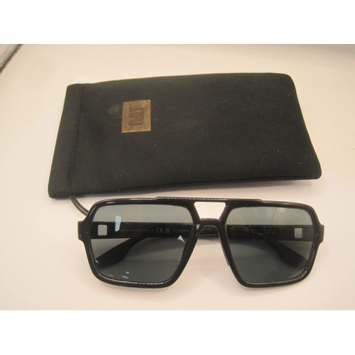 124 - A pair of polarized sunglasses marked Prada, matched with a soft carry case