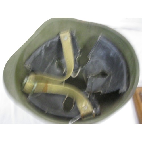 70 - (477) A green painted Army Helmet complete with liner and chin strap.