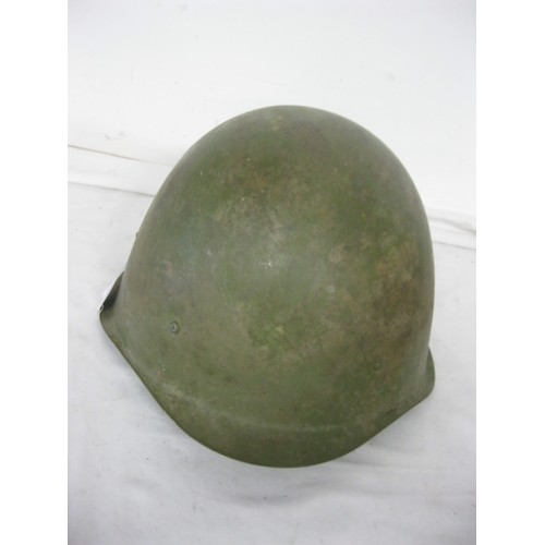 70 - (477) A green painted Army Helmet complete with liner and chin strap.