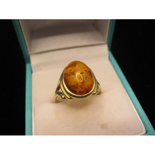 38 - A 9 carat imported gold ring set with an oval amber type stone. Ring size Q/R, gross weight approx. ... 