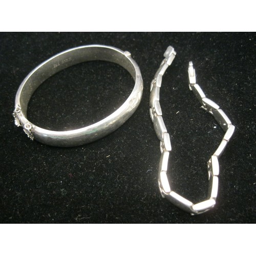 42 - A silver bangle and a silver bracelet. (1) A Birmingham silver half-engraved bangle (a/f dented) wit... 