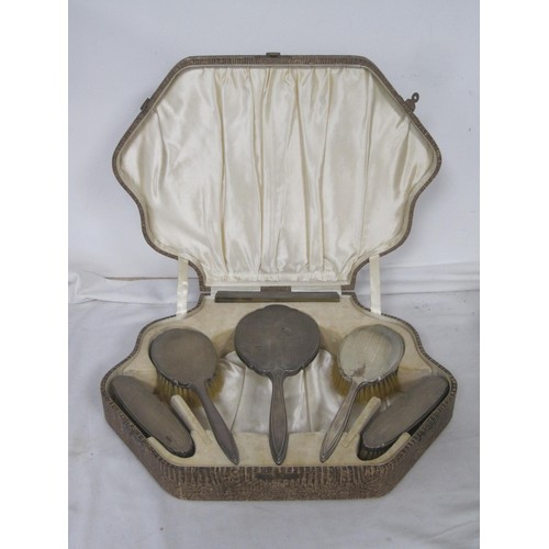 57 - A cased silver-backed engine turned six-piece dressing table set. The fitted case is complete with f... 