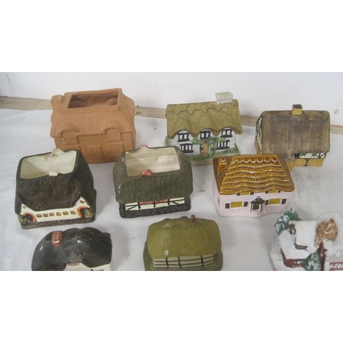 15 - About twelve pottery models of cottages, including Tey Pottery example, and O'Donohue Rye money box