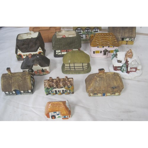 15 - About twelve pottery models of cottages, including Tey Pottery example, and O'Donohue Rye money box