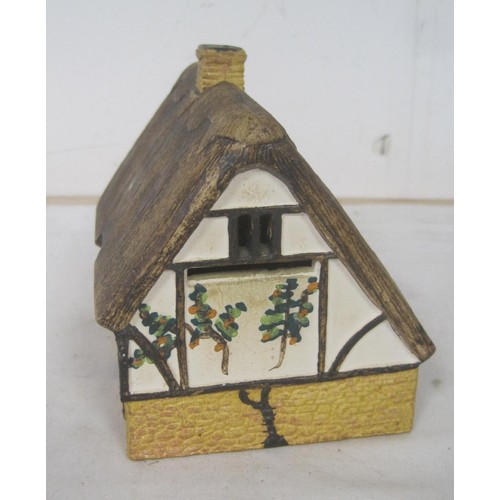 15 - About twelve pottery models of cottages, including Tey Pottery example, and O'Donohue Rye money box