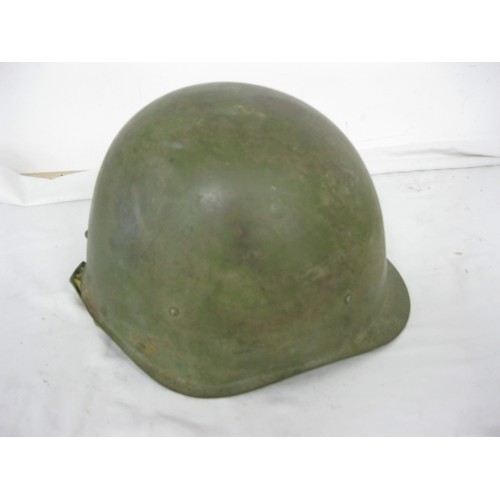 25 - A green painted Army Helmet complete with liner and chin strap.