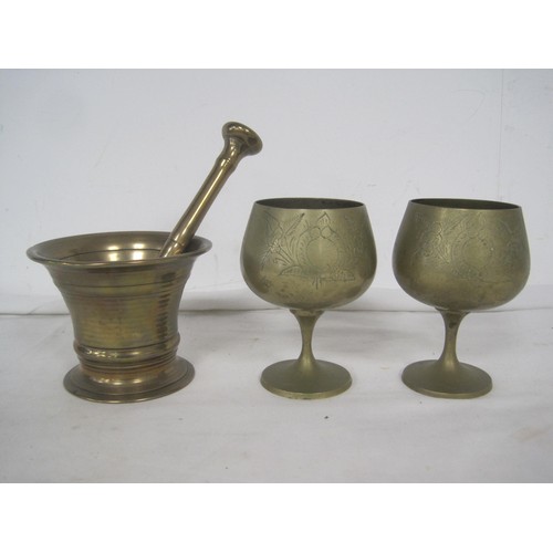 116 - A brass mortar and pestle (length of pestle 19cm), and two engraved brass goblets