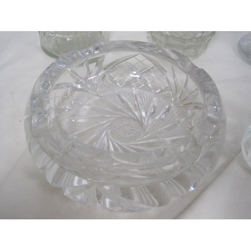 146 - A heavy cut glass ashtray, together with a glass candle holder, and three vases