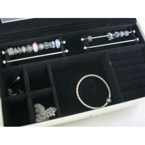 25 - Beige Pandora Box with 2 bracelets, 2 pairs of earrings, and 16 charms