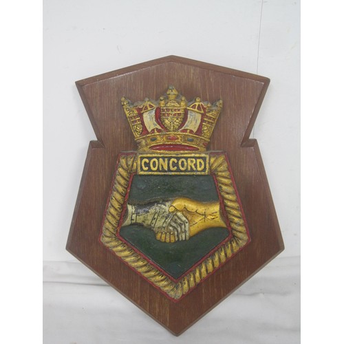 101 - HMS Concord cast plaque mounted on a wood back ,painted and in good condition.