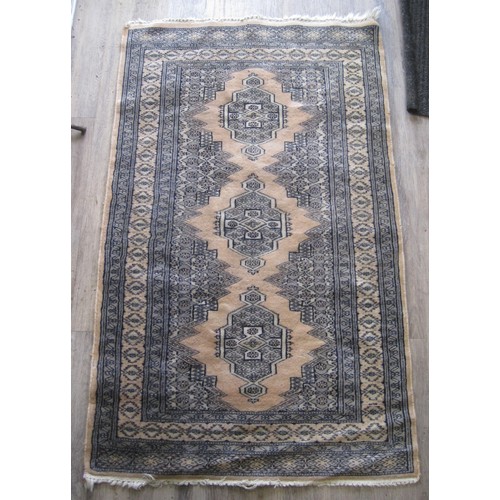 102 - A Middle Eastern rug (130cm x 79cm) with dusky pink ground and three emblems, some a/f wear