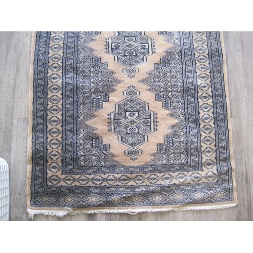 102 - A Middle Eastern rug (130cm x 79cm) with dusky pink ground and three emblems, some a/f wear