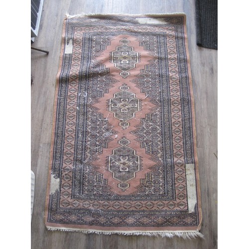 102 - A Middle Eastern rug (130cm x 79cm) with dusky pink ground and three emblems, some a/f wear