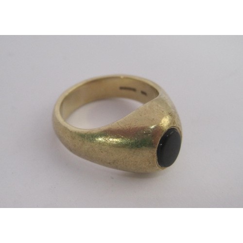 155 - A substantial 9 carat gold gents signet ring set with an un-engraved oval dark stone in a raised set... 