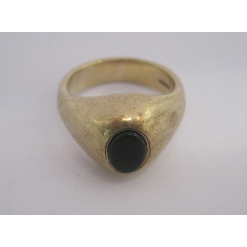 155 - A substantial 9 carat gold gents signet ring set with an un-engraved oval dark stone in a raised set... 