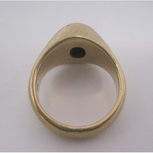 155 - A substantial 9 carat gold gents signet ring set with an un-engraved oval dark stone in a raised set... 