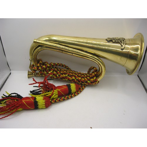 186 - A brass bugle with cord, the bugle bearing the Royal Artillery badge