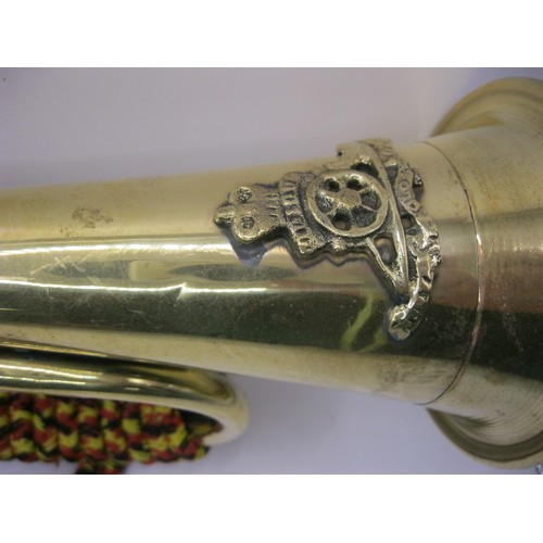 186 - A brass bugle with cord, the bugle bearing the Royal Artillery badge