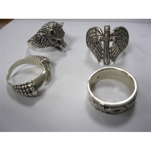 64 - 4 heavy silver gentleman's rings stamped for .925, one featuring a wolf's head, one angel's wings an... 