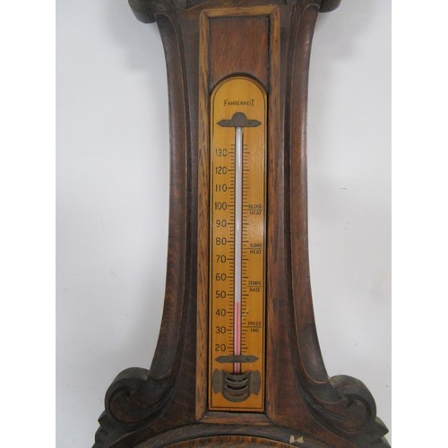 44 - An Aneroid Barometer mounted on a dark wood frame with Thermometer .