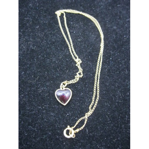 64 - A 9 carat gold necklace with 9 carat gold pendant featuring a red, heart-shaped stone, approx length... 