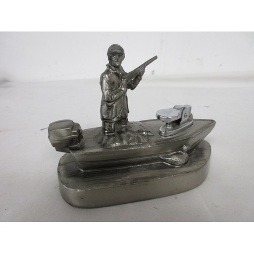 20 - A vintage desk lighter, gas, in the form of a hunter standing in a punt, in white metal.