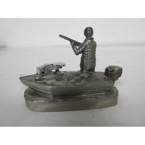 20 - A vintage desk lighter, gas, in the form of a hunter standing in a punt, in white metal.