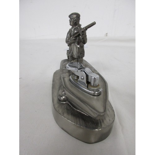 20 - A vintage desk lighter, gas, in the form of a hunter standing in a punt, in white metal.