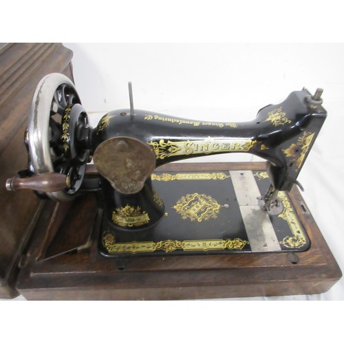 134 - A vintage wooden cased sewing machine made by Singer