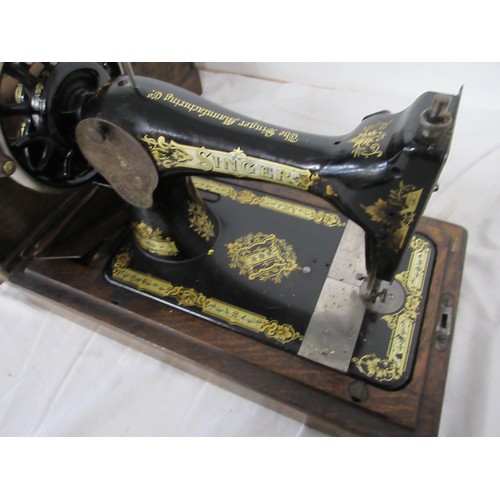 134 - A vintage wooden cased sewing machine made by Singer