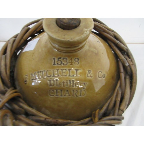 170 - A stoneware flagon for F Mitchell & Co Distillery Chard, in wicker basket