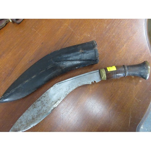 44 - A WW1 military Kukri knife, unmarked steel blade, brass bound hilt in a wooden, leather covered scab... 