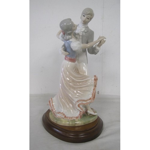 154 - A porcelain lamp base modelled as lady and gentleman dancing, on oval mahogany stand drilled for lig... 
