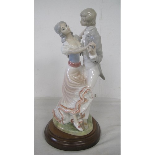 154 - A porcelain lamp base modelled as lady and gentleman dancing, on oval mahogany stand drilled for lig... 