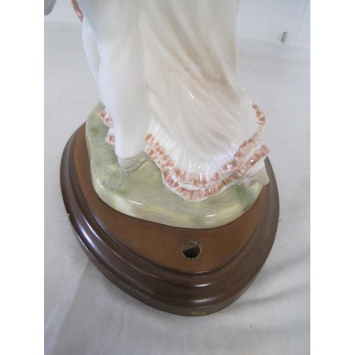 154 - A porcelain lamp base modelled as lady and gentleman dancing, on oval mahogany stand drilled for lig... 