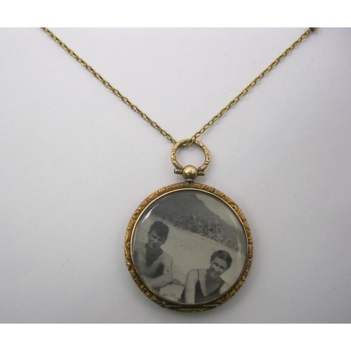6 - A 9 carat gold circular locket pendant on chain. The locket with British hallmarks within, gross wei... 