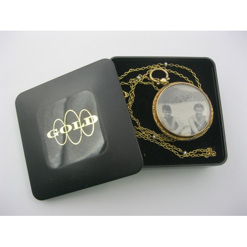 6 - A 9 carat gold circular locket pendant on chain. The locket with British hallmarks within, gross wei... 