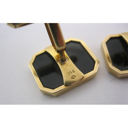 7 - A pair of yellow metal cufflinks set with polished black faces, rectangular with canted corners, one... 