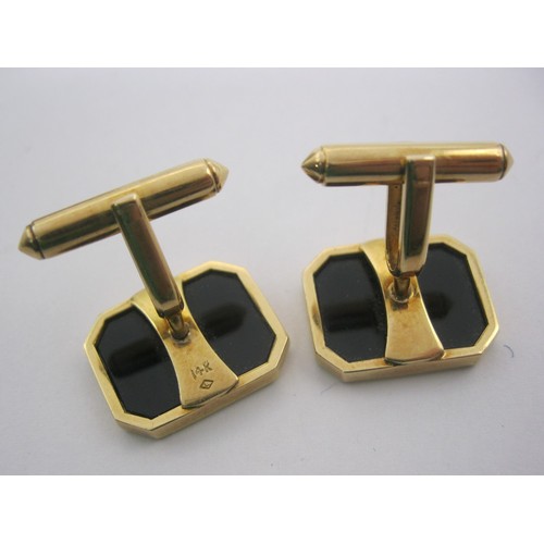 7 - A pair of yellow metal cufflinks set with polished black faces, rectangular with canted corners, one... 