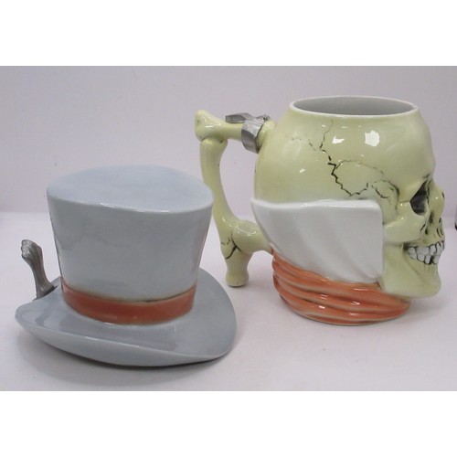 120 - Two German pottery skull tankards or beer steins. One with a serpent handle, the other with a top ha... 